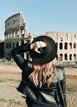 Tourist admiring the Colosseum in Rome, symbolizing Italy tours with inStazione.