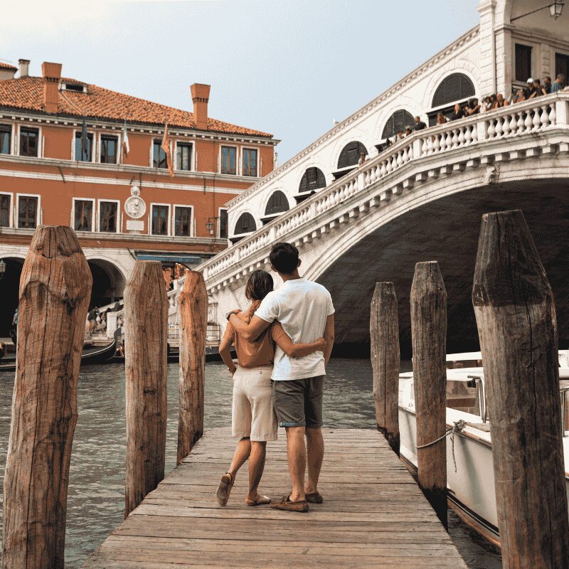 Couple embracing on the historic Rialto Bridge during a Venice guided tour