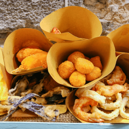 Traditional Neapolitan street food cones filled with fried delicacies, served fresh in Naples, Italy.