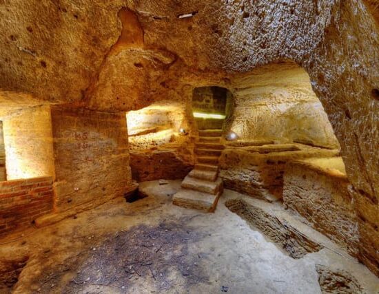 Illuminated ancient underground chambers and archaeological remains at Valle dei Templi in Agrigento.