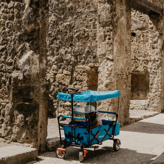 Child riding in a stroller exploring Pompeii ruins