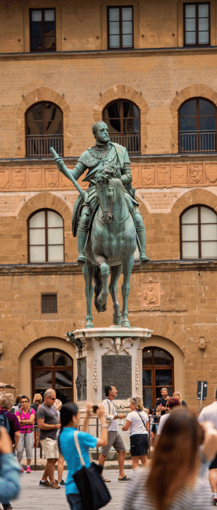 Equestrian statue of Cosimo I de' Medici in Piazza della Signoria, Florence, surrounded by tourists during a Florence walking tour.