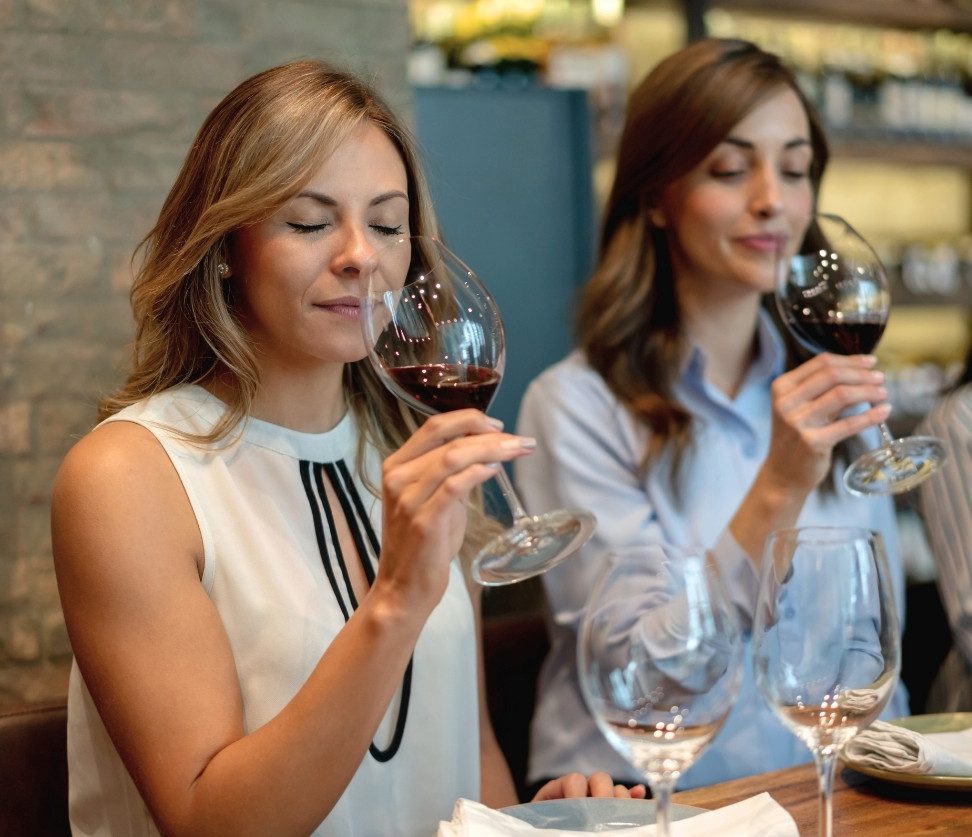 Women savoring red wine during Wine Tour Milano tasting session