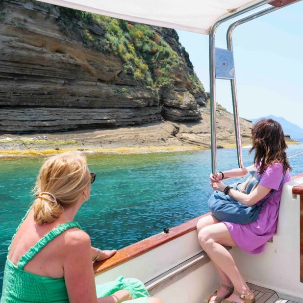 Visitor enjoying scenic views and turquoise waters on Procida island boat tour from Naples